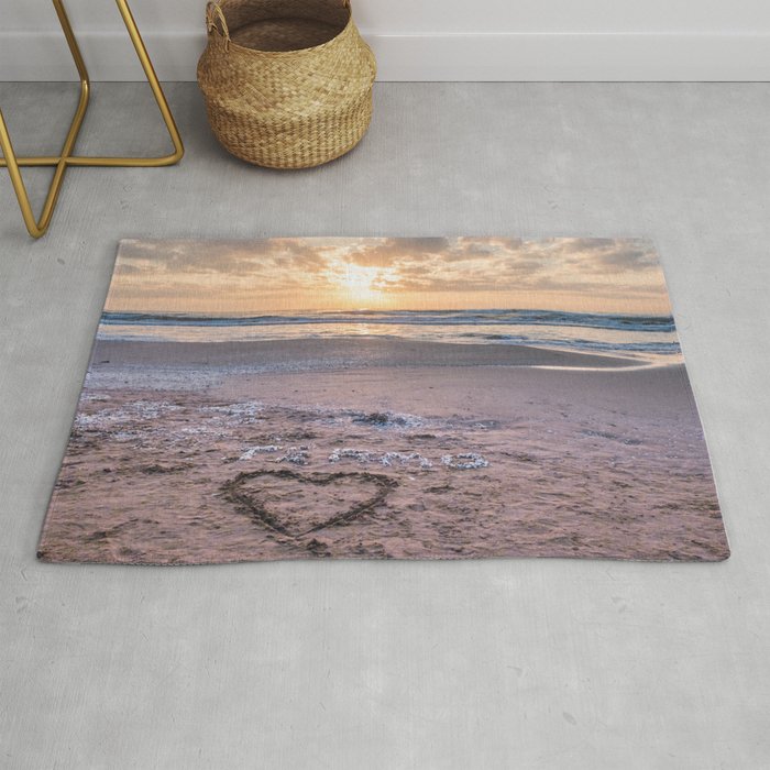 Love note Te Amo with the heart drawing on the beach at sunrise Rug