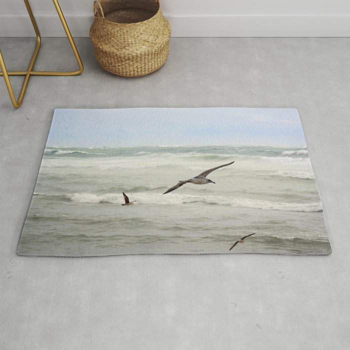Seagulls flying over rough sea Rug