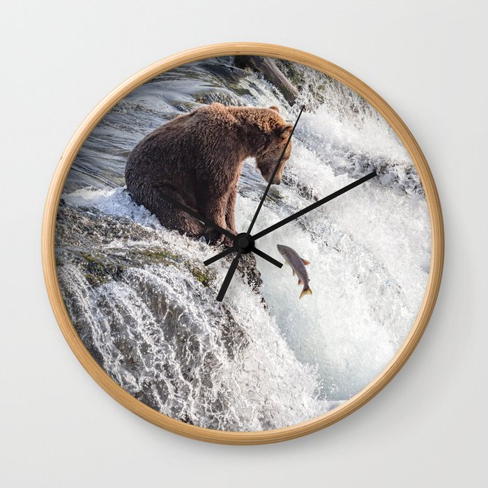Young grizzly bear sits at waterfall Wall Clock