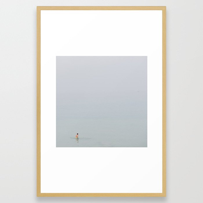 A boy in the sea with a yellow ball Framed Art Print