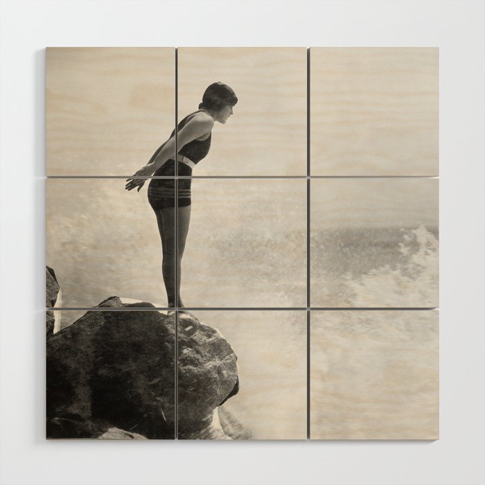 Female swimmer on rock above crashing surf Wood Wall Art