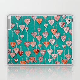 Red, handmade ceramic hearts suspended on hemp strings on a green background. Laptop Skin