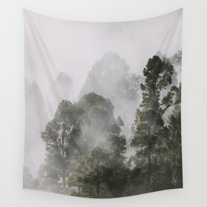 Tall forest trees above the morning mist Wall Tapestry