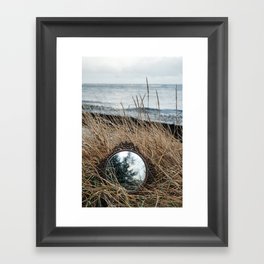 Vintage mirror on seaside reflects forest and sky. Framed Art Print
