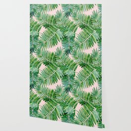 Green palm leaves on a light pink background. Wallpaper