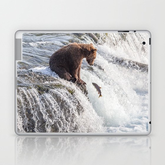 Young grizzly bear sits at waterfall Laptop & iPad Skin