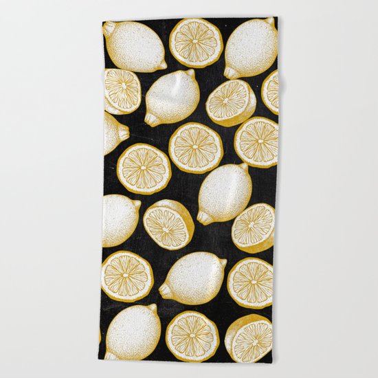 Lemons on black background Beach Towel