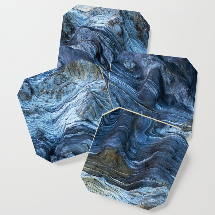 Detail of a rock with variants of blue. Rock full of curves and smooth cuts resulting from the erosive effect of sea. Close up rocks, texture dramatic and colorful erosional water formation. Stone Coaster