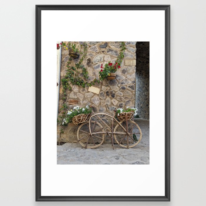 Wood bike with flowers over light brown stone wall with flowers Framed Art Print