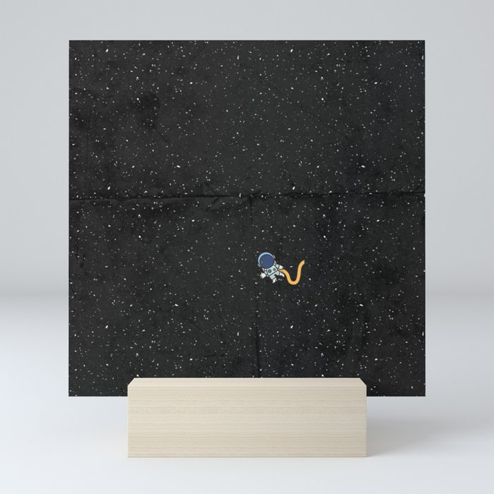 a tiny astronaut lost in the black hole of space Mini Art Print