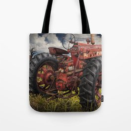 Abandoned Old Farmall Tractor in a Grassy Field on a Farm Tote Bag