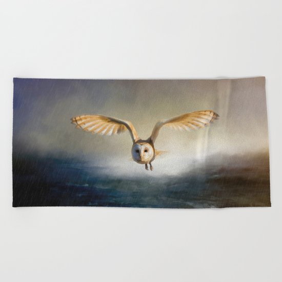 An owl flies over the lake Beach Towel