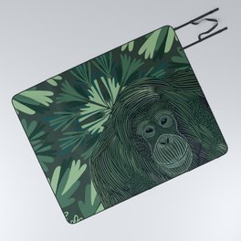 Orangutan in the jungle sitting on a green abstract leafy pattern background Picnic Blanket