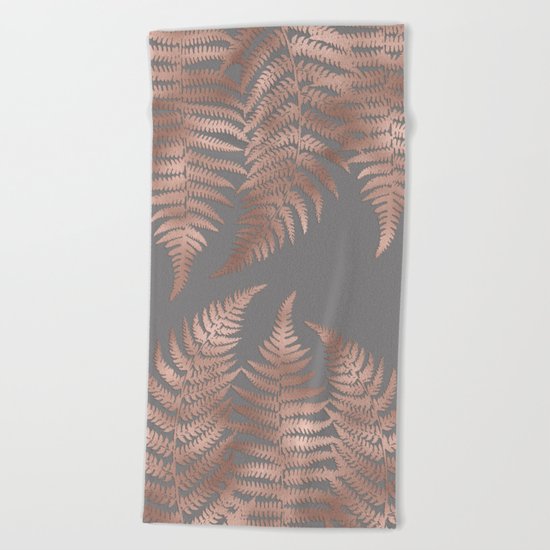 Rosegold pink metal fern leaves on grey background Beach Towel