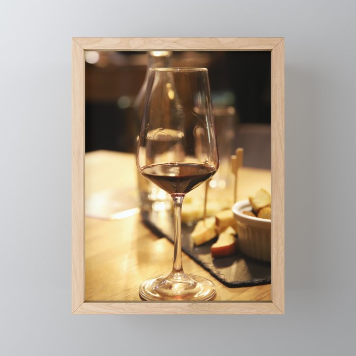 Glass of red wine on a table Framed Mini Art Print