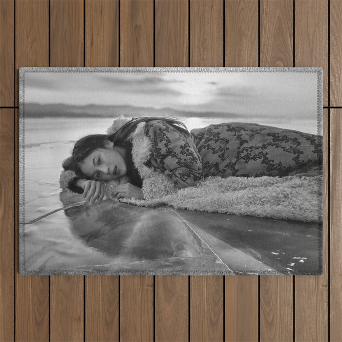 Midnight sun, Iceland; female lying on frozen lake at midnight figurative winter portrait black and white photograph - photography - photographs Outdoor Rug