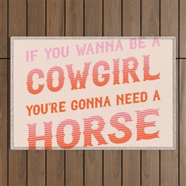 If you wanna be a cowgirl, you're gonna need a horse (pink and orange western style letters) Outdoor Rug