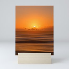 Birds flying across a sunset at the beach Mini Art Print