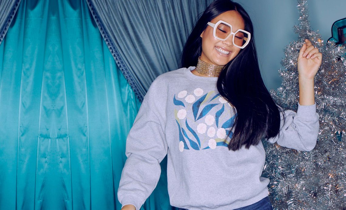 Girl wearing gray and blue holiday sweatshirt