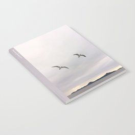 Two Soaring Seagulls | Two Birds Flying Over the Ocean With Cloudy Sky And Island In the Background Notebook