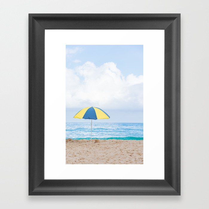 Beach umbrella in beautiful scenery with sand, blue sea and cloudy sky in Trindade, Paraty, Brazil. Framed Art Print