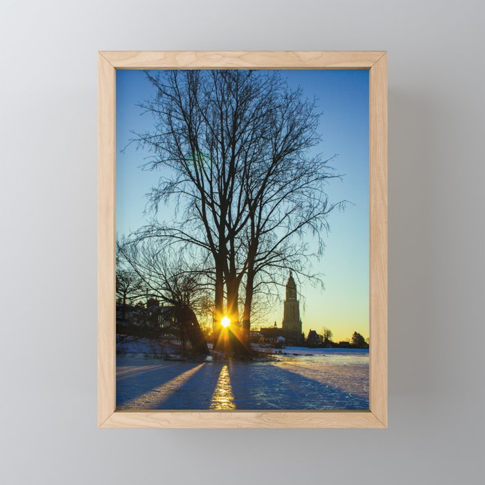 Sunrise on a frozen lake with a little church in the background Framed Mini Art Print