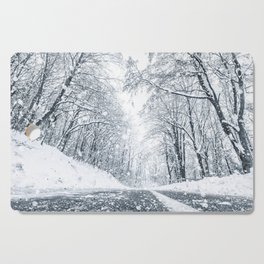 Winter forest snow road. Forest road winter snow view. Cutting Board