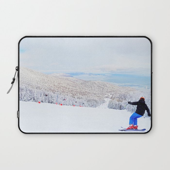 Skier at a ski resort with snowy mountain and lake Laptop Sleeve