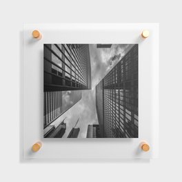 A black-and-white shot of white clouds above towering high-rises in a city Floating Acrylic Print