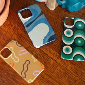 trio of abstract phone cases on a desk