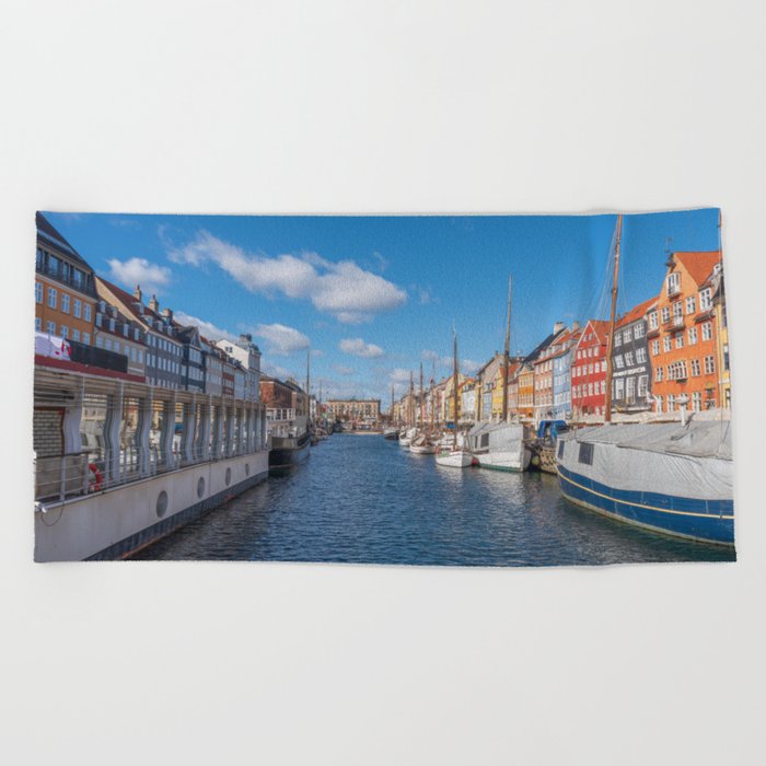 Nyhavn Canal under a blue sky with some clouds Beach Towel