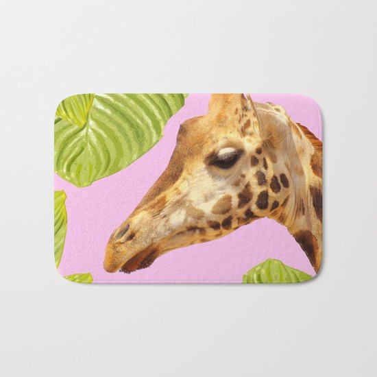 Giraffe with green leaves on a pink background Bath Mat