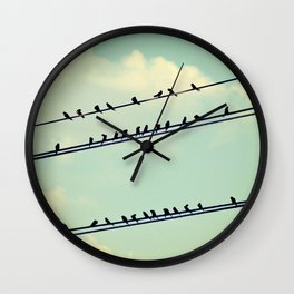 Birds on wires over blue sky with clouds background toned with a vintage retro filter Wall Clock