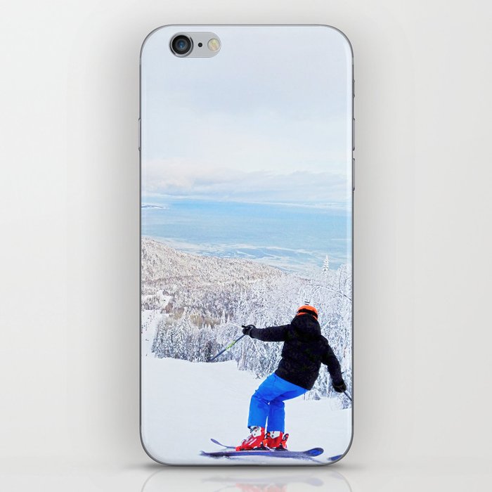 Skier at a ski resort with snowy mountain and lake iPhone Skin