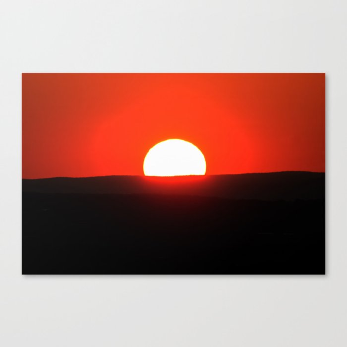 Sun setting over the horizon Canvas Print