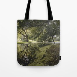 /// Hidden Worlds /// Landscape photograph taken under the lush green trees of a quiet creekside Tote Bag
