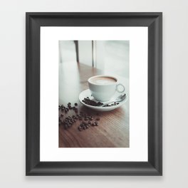 A cup of hot cappuccino placed on a wooden table near with coffee beans Framed Art Print
