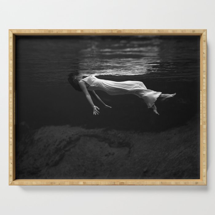 Underwater view of a woman floating in water Serving Tray