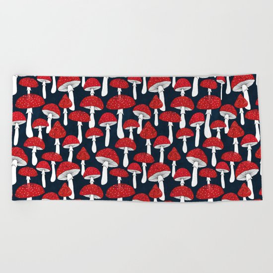 Red mushrooms field on navy blue Beach Towel