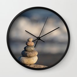 Pebbles stacked on the beach Wall Clock