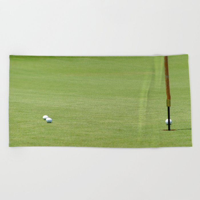 Golf balls near flagstick Beach Towel