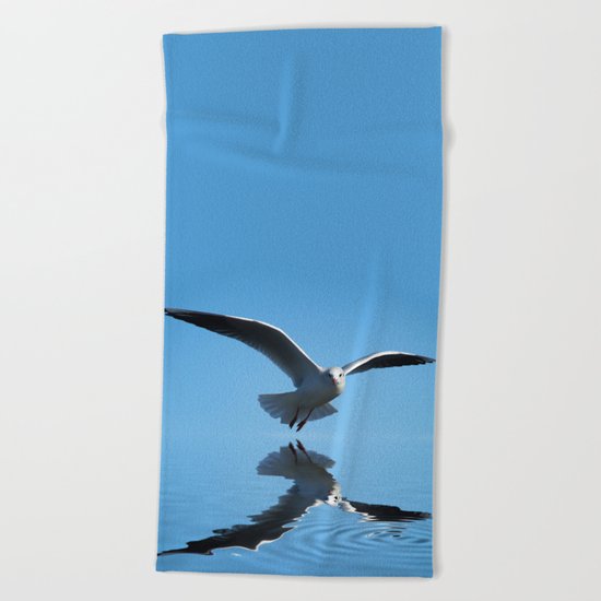 Seagull on blue sky Beach Towel