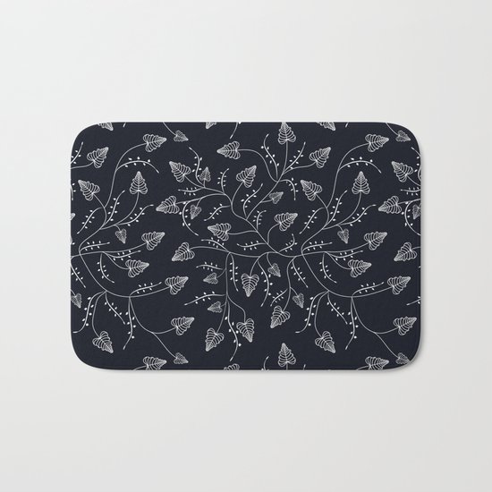 Delicate leaves on a black background . Bath Mat