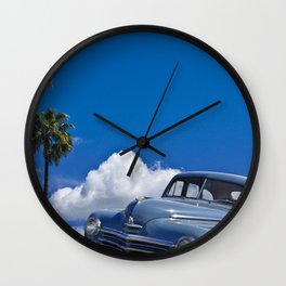 Vintage Blue Plymouth Automobile against Palm Trees and Cloudy Blue Sky Wall Clock