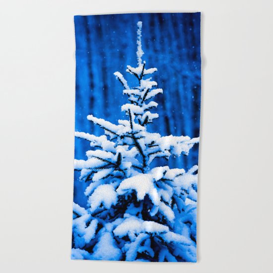 Snow covered Christmas tree Beach Towel