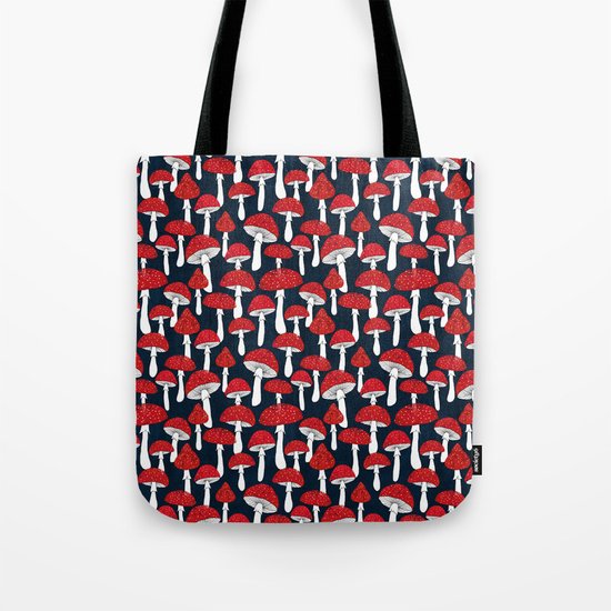 Red mushrooms field on navy blue Tote Bag