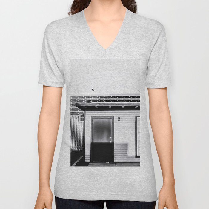 wood building with brick building background in black and white V Neck T Shirt