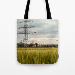 Landscape view of the electric tower over the rapeseed plantation in Germany Tote Bag