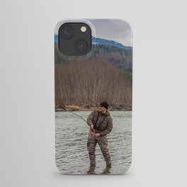 A fly fisherman hooked into a big fish in a the Kalum River, British Columbia, Canada, with the rod bent and aspen woodland on the far bank, and mountains in the background iPhone Case