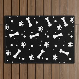 White dog paw and bones pattern on black background Outdoor Rug